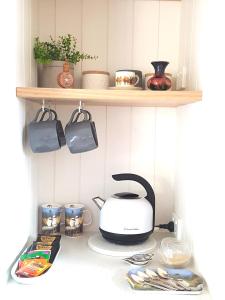 LeongathaAlkira的厨房柜台配有烤面包机和架子上的餐具