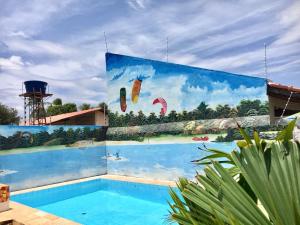 博阿维斯塔Hotel Hostel Caçari的一座带游泳池的建筑的侧面壁画