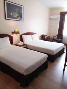 关丹马来西亚关丹斯里酒店的酒店客房带两张床和一张桌子以及椅子。