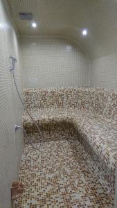 韦林格勒Family Hotel Dalia的一间带软管的瓷砖地板浴室