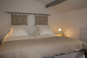 穆斯捷-圣玛丽朱尔旅馆的卧室配有带白色枕头的大床