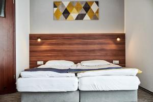 格里兹鲍Szekla的配有木床头板的客房内的两张床