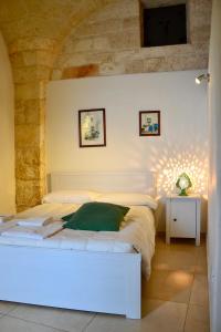 奥斯图尼La Violetta Ostuni的石墙房间内的一张白色床