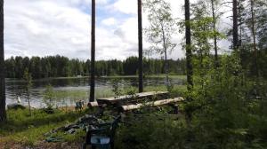 蓬卡哈尤Villa Paradise at Puruvesi Saimaa的树丛湖前的长凳