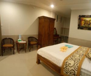 乌布Murdhasari的卧室配有一张床和一张桌子及椅子