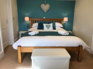Broad ClystCrannaford Cottage的一间卧室配有一张带蓝色墙壁的大床