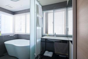 札幌Private house Kuranoya Sapporo的带浴缸和盥洗盆的浴室