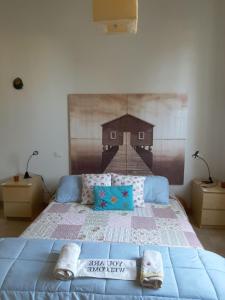 蒂勒尼亚Sea beach relax的卧室配有一张大床,墙上挂有绘画作品