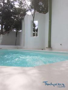 阿达玛斯Thalassitra Private Pool Suites & Spa的大楼前的蓝色海水游泳池