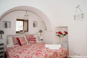 普蒂尼亚诺Giardino Segreto的一间卧室配有一张带红色枕头的大床