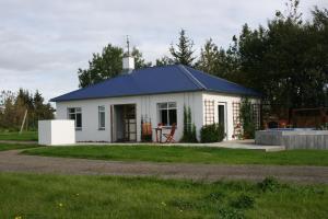 BærJadar Farm的蓝色屋顶的白色小房子