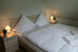 HerschbroichFerienhaus im Nürburgring的一张带两个枕头和两盏灯的白色床
