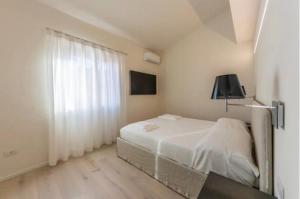 切尔沃港Appartamento Il Principe的白色的卧室设有床和窗户