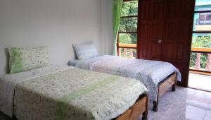 查汶苏梅岛帕瑟旅舍的一间卧室设有两张床和窗户。