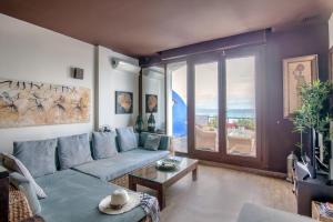 塔里法Lances Beach Penthouses的客厅设有蓝色的沙发和大窗户