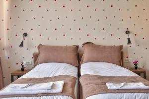 普里什蒂纳Boulevard Prishtina的卧室内的两张床,墙上有红色点