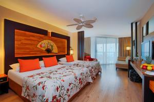 拉瑞Limak Lara Deluxe Hotel & Resort Antalya的酒店客房配有一张带橙色枕头的大床