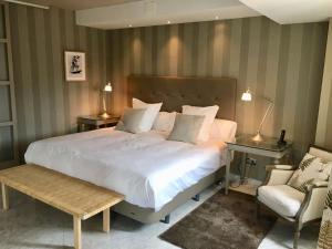 奥维多奥维多自然酒店的卧室配有一张白色大床和一把椅子