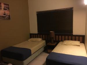 Kampong Tanjong PechahBestari Homestay @ Gold Coast Morib的两张床位于带窗户的房间内