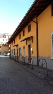 特伦托艾特波托尼住宿加早餐旅馆的一条黄色的建筑,街道旁有一排门