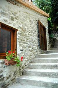 VicdessosArcogite的石头建筑,有楼梯,门和花