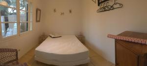 耶尔Le Club des Cigales的一间位于客房角落的带一张床的房间