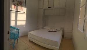 耶尔Le Club des Cigales的一间白色的小卧室,配有一张床和一把椅子