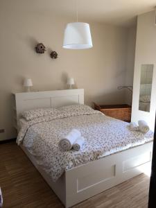 代森扎诺-德尔加达Horto Terapeutico Home的一间卧室配有带毛巾的床