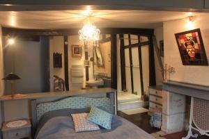 贝尔热拉克乐瑞莱德拉米普公寓 的一间卧室配有一张床、一个壁炉和一个吊灯。