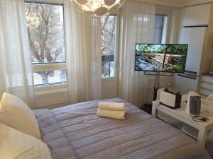 罗瓦涅米City Apartments With Balcony的一间卧室设有一张大床,内配电视