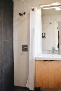 贝灵厄姆Heliotrope Hotel的浴室设有白色的淋浴帘和水槽