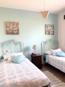 阿亚蒙特Mi trocito de Cielo Ayamonte的一间卧室配有两张床和一张带台灯的桌子