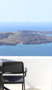 易莫洛林Agave Santorini Design Boutique Hotel的一张长椅,坐在阳台上,俯瞰着一排水面