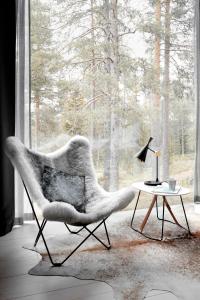 罗瓦涅米北极树屋酒店 的窗户房间里一张椅子和一张桌子