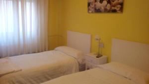 潘普洛纳潘普洛纳客房旅馆的黄色墙壁客房的两张床