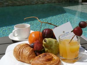 圣丹尼斯郁金香圣克洛蒂尔德酒店的一盘水果、羊角面包和一杯橙汁