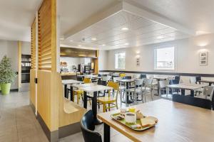 梅济约B&B HOTEL Lyon Grand Stade Meyzieu的用餐室配有桌子和黄色椅子