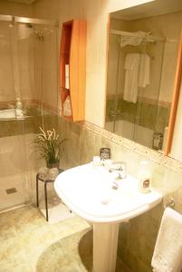 莱昂Apartamentos Turisticos ARCH的浴室配有白色水槽和淋浴。