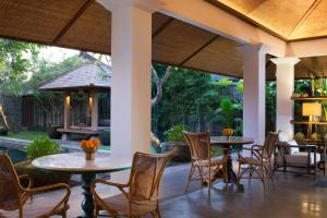 沙努尔Atelier TE Designer Guesthouse的一个带桌椅的庭院和一个游泳池