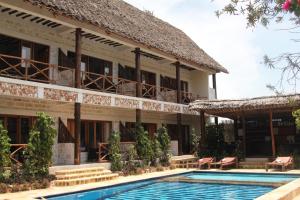 马特姆维Tamani Villas - Annex的大楼前设有游泳池的酒店