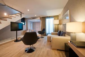 马拉加普桑达帕提欧斯莱克森温齐酒店的客厅配有沙发和电视。