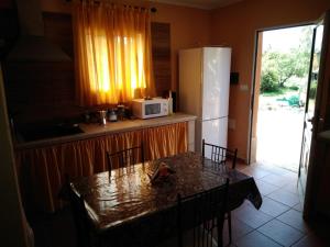 蓬塔戈尔达Casa roko的厨房配有桌椅和冰箱。