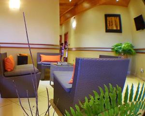 图利亚拉Hôtel Serena的一间房间,配有两把椅子、一张沙发和一个植物