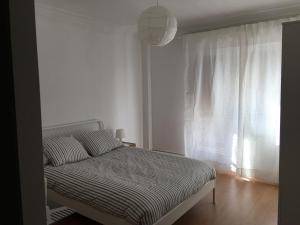 韦斯卡Apartamento Huesca en Paseo Ramón y Cajal的白色客房的一张床位,设有窗户