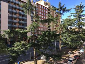 韦斯卡Apartamento Huesca en Paseo Ramón y Cajal的树木繁茂的城市公寓大楼