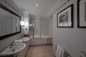 HopwoodWestmead Hotel Bar & Restaurant的浴室配有2个盥洗盆、淋浴和浴缸。