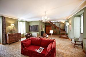 博讷Le Clos Sainte-Marguerite的一间带红色沙发的客厅和楼梯