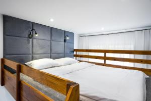 克拉科夫Apartament Felicjanek的一间卧室配有一张带白色床单的木床