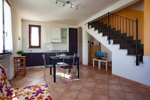 苏韦雷托La Fonte degli Angeli Apartments的厨房以及带桌子和楼梯的客厅。