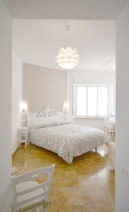 莱万托Villa Mori的白色卧室配有床和椅子